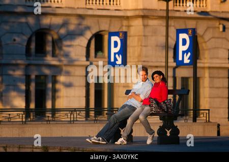 September 2015 - Brüssel, Belgien - Poelaert Square, Marolles Nachbarschaft, Brüssel, Belgien. Ein romantisches Paar, das auf einer Bank auf dem Platz neben dem Aufzug sitzt, Poelaert Marolles. Zum Herunterladen aus der Nachbarschaft Sablon nach Marolles können ungewöhnliche Verkehrsmittel genutzt werden, ein kostenloser Aufzug komplett aus Glas, von dem aus man einen herrlichen Blick über Marolles genießen kann. Er wurde gelegt, um die Lücke zu schließen, die den Palast Les Marolles trennt. Auf dem Gipfel (Platz Poelaert) gibt es einen Aussichtspunkt, von dem einige der berühmtesten Gebäude der Stadt sind. (Bild: © Sergi Reboredo/ZUMA Wire/ZUMAPRESS.com) Stockfoto