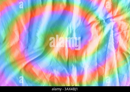 Helles, mit Tie-Dye-Technik gefärbtes Gewebe. Textil mit Wirbeln in Regenbogenfarben Stockfoto