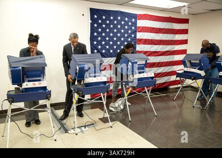 20. Oktober 2014 - Chicago, IL, USA - US-Präsident Barack Obama gibt seine Stimme während der frühen Abstimmung im Martin Luther King Jr. ab Community Center 20. Oktober 2014 in Chicago, IL. Der Wahlkollege Mike Jones, ganz rechts, sagte: "Mr. President, berühre meine Freundin nicht." als der Präsident mit der Abstimmung fertig war, Griff er zu ihm und gab Cooper einen Kuss auf die Wange. . Barack Hussein Obama II (* 4. August 1961) ist der 44. Präsident der Vereinigten Staaten. Er ist der erste Afroamerikaner, der ins Amt gewählt wurde und der erste Präsident, der außerhalb der angrenzenden Vereinigten Staaten geboren wurde. Geboren in Honolulu, Hawaii, Geburtshilfe Stockfoto