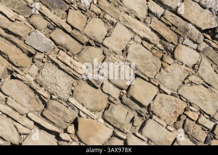 Alte unregelmäßige Steinmauer mit Natursteinen - Steinmauer und Hintergrund Stockfoto