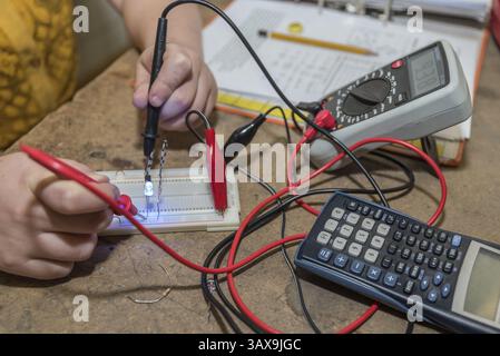 Elektroingenieur, der an seinem Arbeitsplatz mit einem Spannungsprüfer arbeitet – Nahaufnahme Stockfoto