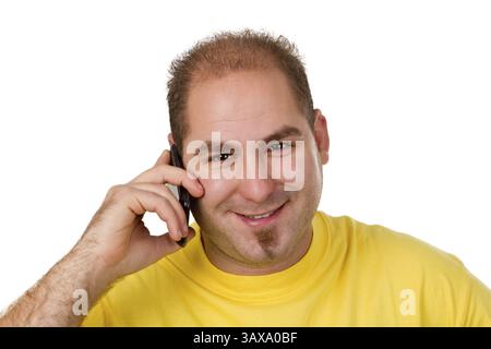 Junger Mann in einem gelben Hemd am Telefon - isoliert junger Mann in einem gelben Hemd am Telefon - isoliert Stockfoto