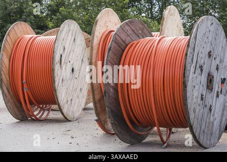 Orangefarbenes Glasfaserkabel auf hölzernen Kabeltrommeln - schnelles Internet Stockfoto