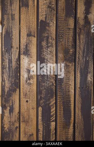 Dunkle, ungleichmäßig lackierte Holzlatten - Nahaufnahme der vertikalen Holzwand Stockfoto