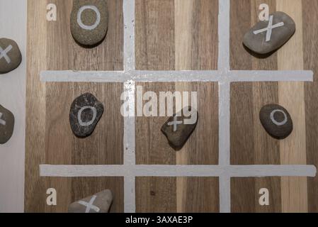 Einfaches Kinderspiel für zwei Personen - Tic-Tac-Toe mit Steinen Stockfoto