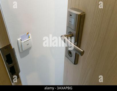 Offene Tür mit elektrischem Schloss und Schlüsselkarte im Hotelzimmer. Stockfoto