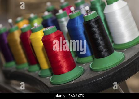 Garn in hellen Farben auf Nähspulen - Nahaufnahme von Nähseide Stockfoto