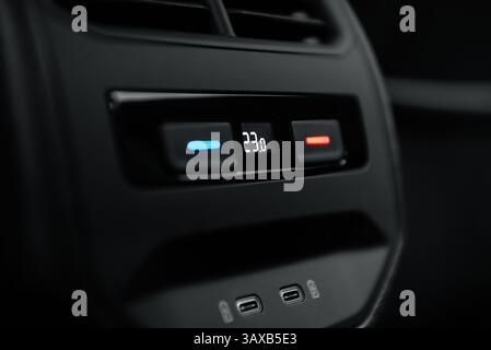 Lüftungssteuerung in einem Auto. Bedienelemente der Klimaanlage für die Fondpassagiere mit zwei Ladeanschlüssen unten. Stockfoto