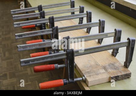 Viele Schraubzwingen drücken Sie frisch geklebt Holzbrett - close-up Stockfoto
