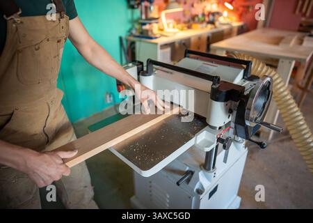 Erfahrener Handwerker, der mit Holz an Hobeldickengelenken arbeitet, Möbelmaterialien vorbereitet Stockfoto