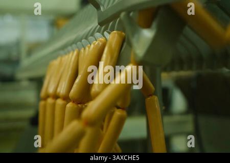 Würstchen hängen auf dem Regal. Herstellung von Würsten auf dem Wasser. Stockfoto