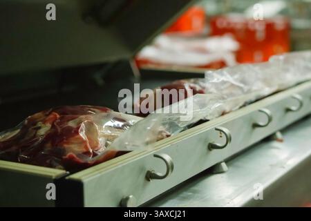 Beutel mit gefrorenem Fleisch auf einem Tablett. Beutel mit gefrorenem Fleisch auf einem Tablett. Stockfoto