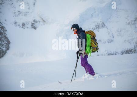 Eine Skirennläuferin steht im Schneesturm Stockfoto