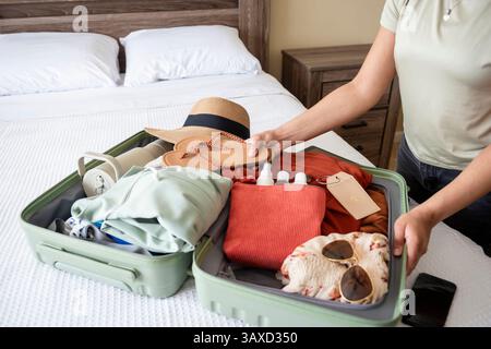 Flip-Flops in Koffer voller Kleidung packen Stockfoto