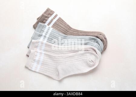 Verschiedene weiche Socken auf hellbeigem Hintergrund, Draufsicht Stockfoto