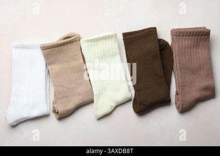 Verschiedene weiche Socken auf hellbeigem Hintergrund, Draufsicht Stockfoto