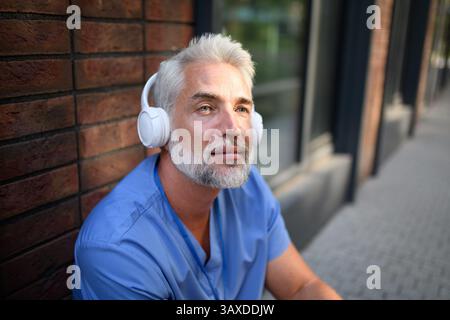 Medizinisches Personal, das sich mit Musik außerhalb des Krankenhauses entspannt. Stockfoto