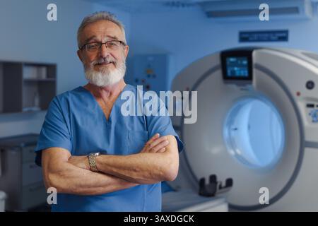 Medizinischer Spezialist steht neben dem CT-Scanner, Blick auf die Kamera, Krankenhausumgebung. Stockfoto