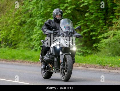 Milton Keynes, Großbritannien - 9. April 2025: Mann fährt einen BMW. Motorrad auf einer britischen Landstraße Stockfoto