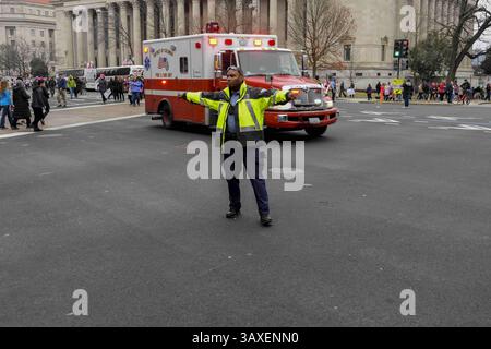 21. Januar 2017: Washington, District of Columbia, U.. S - Ein Polizist in Washington DC. Lenkt den Verkehr an der Kreuzung der 7th und Pennsylvania Avenue. NW während des Frauenmarsches auf Washington als ein Krankenwagen vom District of Columbia Fire Department macht einen Nottransport durch die Menschenmassen. (Kreditbild: © Mark Reinstein via ZUMA Wire) Stockfoto