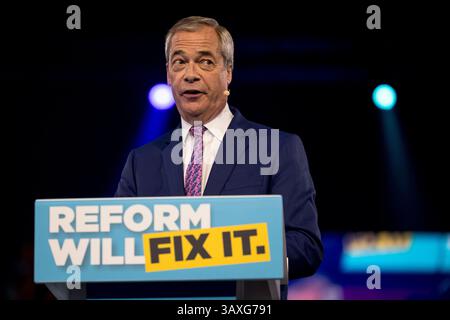 Nigel Farage, Vorsitzender und Parlamentsabgeordneter von Clacton, spricht während der Wahlkampfkundgebung der Reformpartei in der Utilita Arena in Birmingham, England, an die Menge. Stockfoto