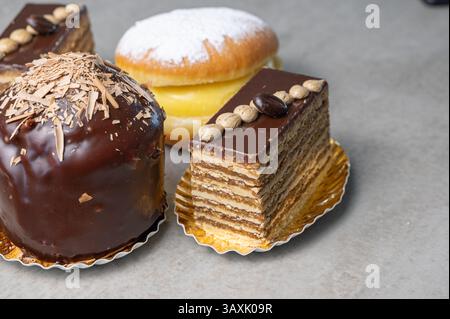 Eine köstliche und exquisite Auswahl an frisch zubereiteten Backwaren, einschließlich mehrschichtigen Kuchen und einem cremegefüllten Donut Stockfoto