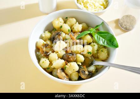 Kartoffelgnocchi mit Butter, Käse und Gemüse in der Schüssel auf hellem Hintergrund. Nahansicht Stockfoto