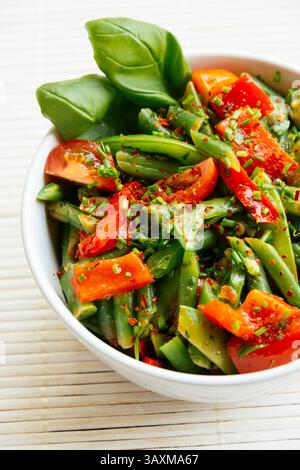 Frühlingssalat mit grünen Bohnen, Zuckererbsenschoten, rotem Paprika und Kirschtomaten. Stockfoto