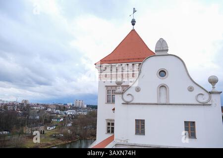 Grodno, Weißrussland, 03.01.2025 Ein weißes Gebäude mit einem roten Dach und einem Kreuz oben. Das Gebäude liegt in einer Stadt mit bewölktem Himmel Stockfoto