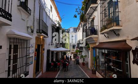 Charmante enge Straße mit weiß getünchten Gebäuden, Restaurants und Geschäften in der Altstadt von Marbella, einem beliebten Touristenziel in Spanien - MARBEL Stockfoto