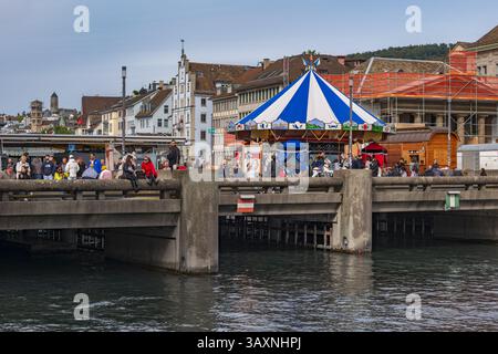 Zürich, Schweiz - 29. September 2024 - Menschen auf der Rathausbrücke mit Karussell auf der Limmat im Stadtzentrum. Stockfoto