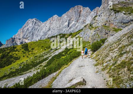 Wanderer auf dem schmalen Kieselwanderweg unter der Südwand des Dachsteins, Steiermark, Österreich, Europa Stockfoto
