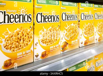 Nestle Honey Cheerios Müslischachteln im Einzelhandelsregal auf Lager. Die ikonische Marke für gemischte Vollkornbrei ist eine klassische Marke. Stockfoto