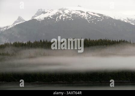 30. Juni 2016 – Juneau, Alaska, USA – Berge am Dawes-Gletscher, Endicott Arm, Tongass National Forest, Alaska, USA. Fjorde mit Klippenmauern, die in das bergige Festland geschnitten sind, sind heute vom Fass, während Sie langsam in eine Gegend schlüpfen, die weithin als die schönste in Alaska gilt. Mit mehr ausgewiesenen Wildnisgebieten als jeder andere Bundesstaat der Nation, sind Endicott Arm und Fordâ's Terror, eine unberührte Flutbucht und ein Fjord. Erkunden Sie diesen majestätischen Fjord mit dem Kajak oder Skiff, eine einzigartige Gelegenheit. Sehen Sie schroffe, eisbedeckte Berge, die hoch über dem Himmel glänzen, und einen Gletscher, der aktiv ins Wasser kältet Stockfoto