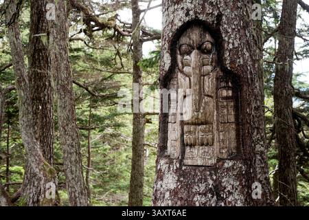 30. Juni 2016 – Juneau, Alaska, USA – Schild, das Raven-Clan-Territorium, Baumschnitzerei, Tlingit-Indians, Juneau, Südost-Alaska. Roberts Montieren. Trekking von der Mt. Roberts Tramway, Juneau. Alaska. Das oberste Terminal der Straßenbahn befindet sich auf einem Turm und bietet einen spektakulären Blick auf die Stadt Juneau und den Gastineau Channel, Douglas Island und die Gemeinde Douglas im Westen, die Chilkat Mountain Range im Norden und Kupreanof Island im Süden. Der Terminalsteig wird durch die Skybridge mit dem Bergrücken des Mount Roberts verbunden, die zu den Gipfelanlagen führt. Das Hauptgebäude umfasst Stockfoto