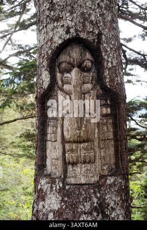 30. Juni 2016 – Juneau, Alaska, USA – Schild, das Raven-Clan-Territorium, Baumschnitzerei, Tlingit-Indians, Juneau, Südost-Alaska. Roberts Montieren. Trekking von der Mt. Roberts Tramway, Juneau. Alaska. Das oberste Terminal der Straßenbahn befindet sich auf einem Turm und bietet einen spektakulären Blick auf die Stadt Juneau und den Gastineau Channel, Douglas Island und die Gemeinde Douglas im Westen, die Chilkat Mountain Range im Norden und Kupreanof Island im Süden. Der Terminalsteig wird durch die Skybridge mit dem Bergrücken des Mount Roberts verbunden, die zu den Gipfelanlagen führt. Das Hauptgebäude umfasst Stockfoto