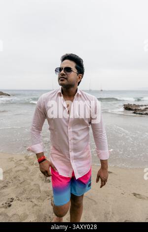 Ein reicher Indianer am Strand, der sich entspannt und seinen Urlaub genießt, mit Sonnenbrille. Stockfoto