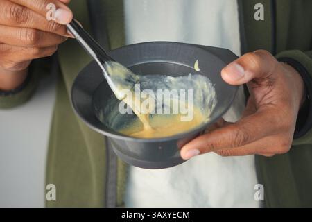 Mischen Sie Haarfarbe in einer Schüssel mit einer Bürste während einer Salonsitzung Stockfoto