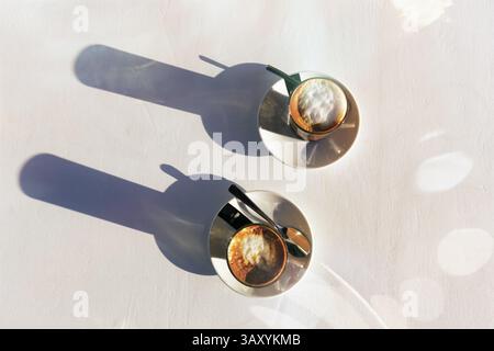 Cortado-Kaffee, spanische Kaffeespezialität von oben, Espresso mit Milchschaum in zwei Gläsern, Abendsonne, Lichtreflexe, symbolisches Bild eines Cafés¿½ Stockfoto