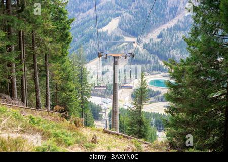 Blick auf die Hütten des Sessellifts vor der Kulisse der Berge und Wälder Stockfoto