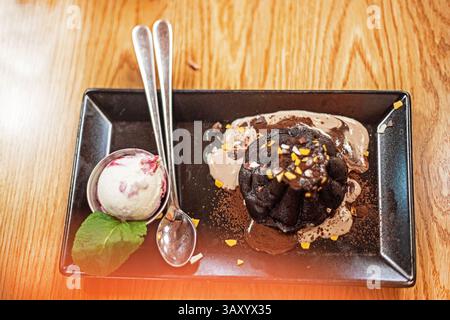 Schokoladenfondant mit Eiskugel und Minzblatt Stockfoto