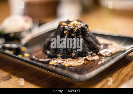 Heißer Schokoladenfondant mit Eiskugel und Minzblatt Stockfoto