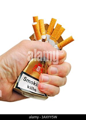 Die Hand zerquetscht eine Schachtel Zigaretten, schneidet sie aus Stockfoto