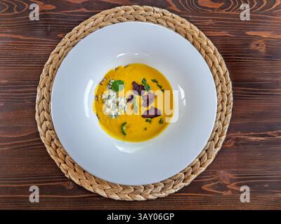 Gourmet-cremige gelbe Suppe mit Blaukäse und geräucherter Fleischgarne. Top View: Köstliche Suppe mit Blaukäse und Fleischscheiben. Cremige Maissuppe mit Blu Stockfoto