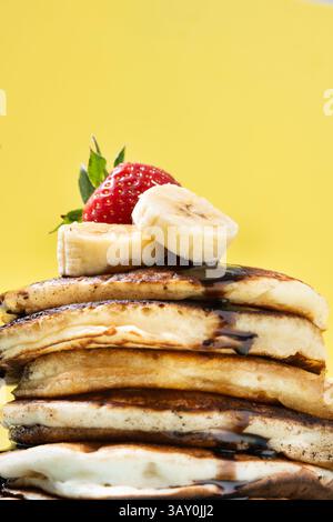 Pfannkuchen mit Schokolade, Erdbeere und Banane auf gelbem Hintergrund Stockfoto