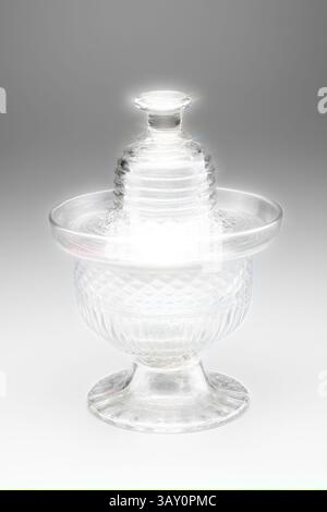 Ein wunderschön gefertigter Glasbehälter mit einem komplizierten Muster, abgerundeter Basis und einem dekorativen Deckel, der elegant über den Rand des Glases ragt. Seine durchscheinende Oberfläche fängt das Licht ein und unterstreicht sein zartes Design., Unknown (American), Sugar Bowl, zwischen 1815 und 1825, geblasenes dreiteiliges Glas, insgesamt 3/4 17,1 x 3/4 12,1 cm, Klassische Kunst mit einem modernen Twist, neu interpretiert von Artotop Stockfoto