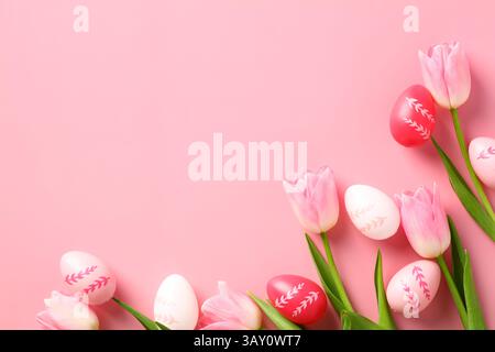Happy Easter-Konzept. Ostergrußkartenschablone mit bunten Ostereiern und Tulpen auf rosa Hintergrund. Stockfoto