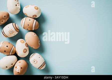 Eleganter Blumendruck mit Ostereiern auf pastellblauem Hintergrund. Flach, Draufsicht mit Kopierraum. Stockfoto