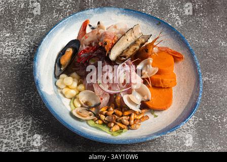 Frisches Ceviche, ein traditionelles peruanisches Gericht, das mit einer Mischung aus Meeresfrüchten, Süßkartoffeln, Mais und knusprigen Maisnüssen besticht Stockfoto