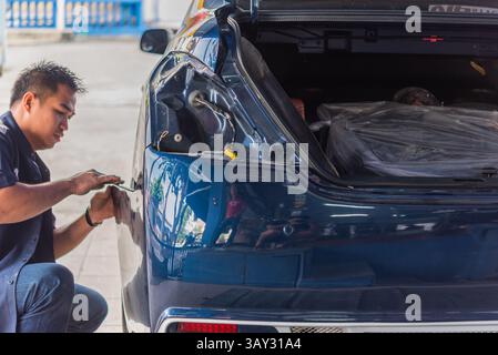 Bangkok, Thailand - 13. Januar 2018 : ein unbekannter Automechaniker oder Servicemitarbeiter überprüft und repariert Karosserieteil für neue Autoschürze in der Autogarage oder Stockfoto